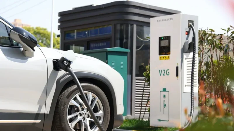 Electric vehicle plugged into a vehicle-to-grid charging station